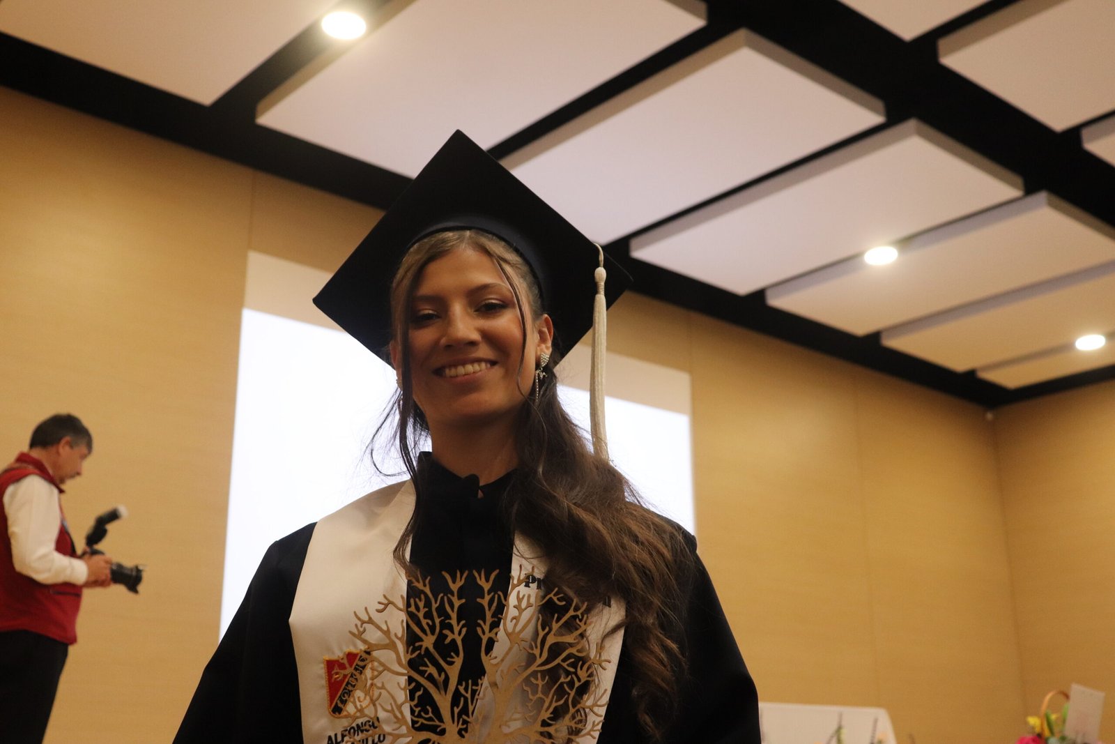 Imagen de una de nuestras alumnas el dia de su grado, mostrando su mención de honor.