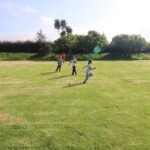 Imagen de la cancha de futbol del colegio, con niños en clase de educación física.