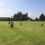 Imagen de la cancha de futbol del colegio, con niños en clase de educación física.