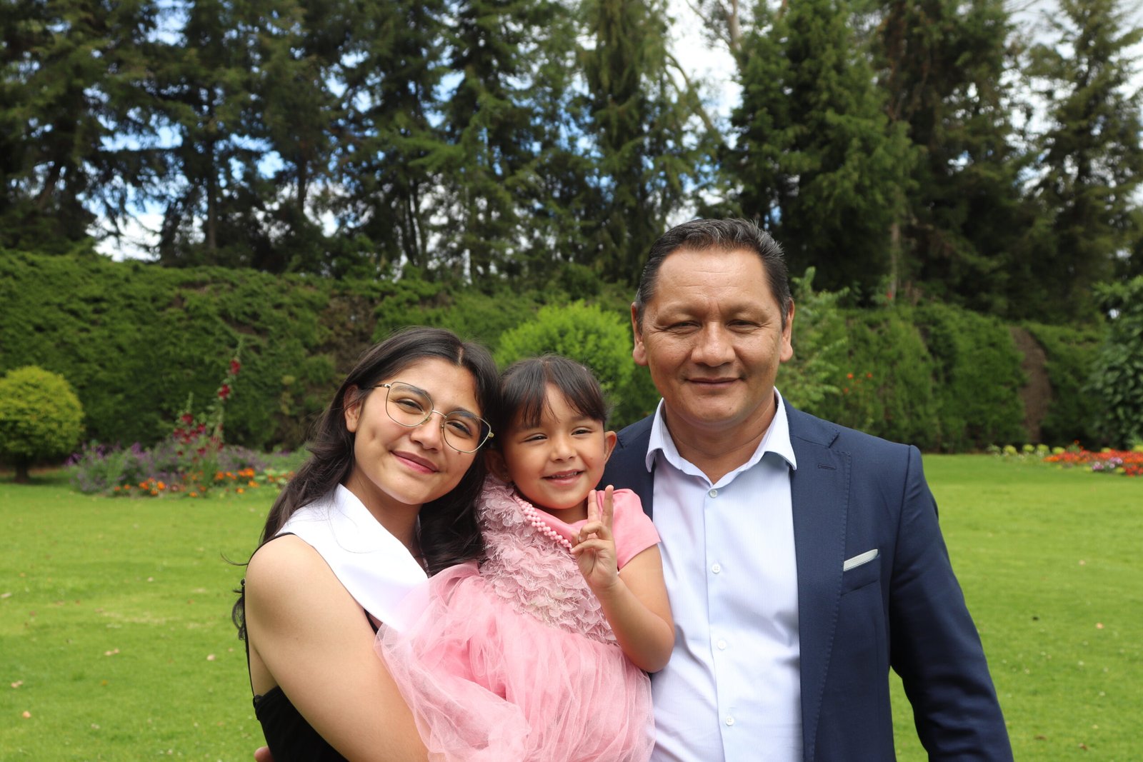 Imagen de una de nuestras alumnas el dia de su grado, con su pequeña hermana y su papá.